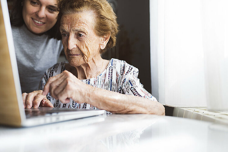 Young woman and Grandmother using laptop together.